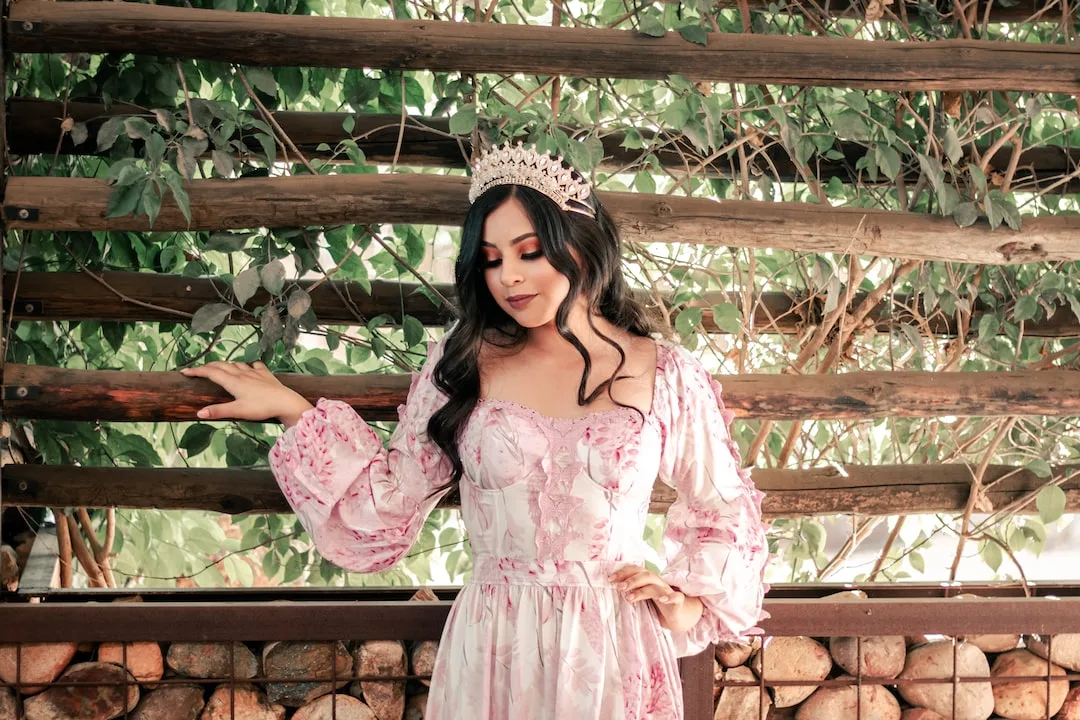 Portrait with pink floral crown at a garden trellis