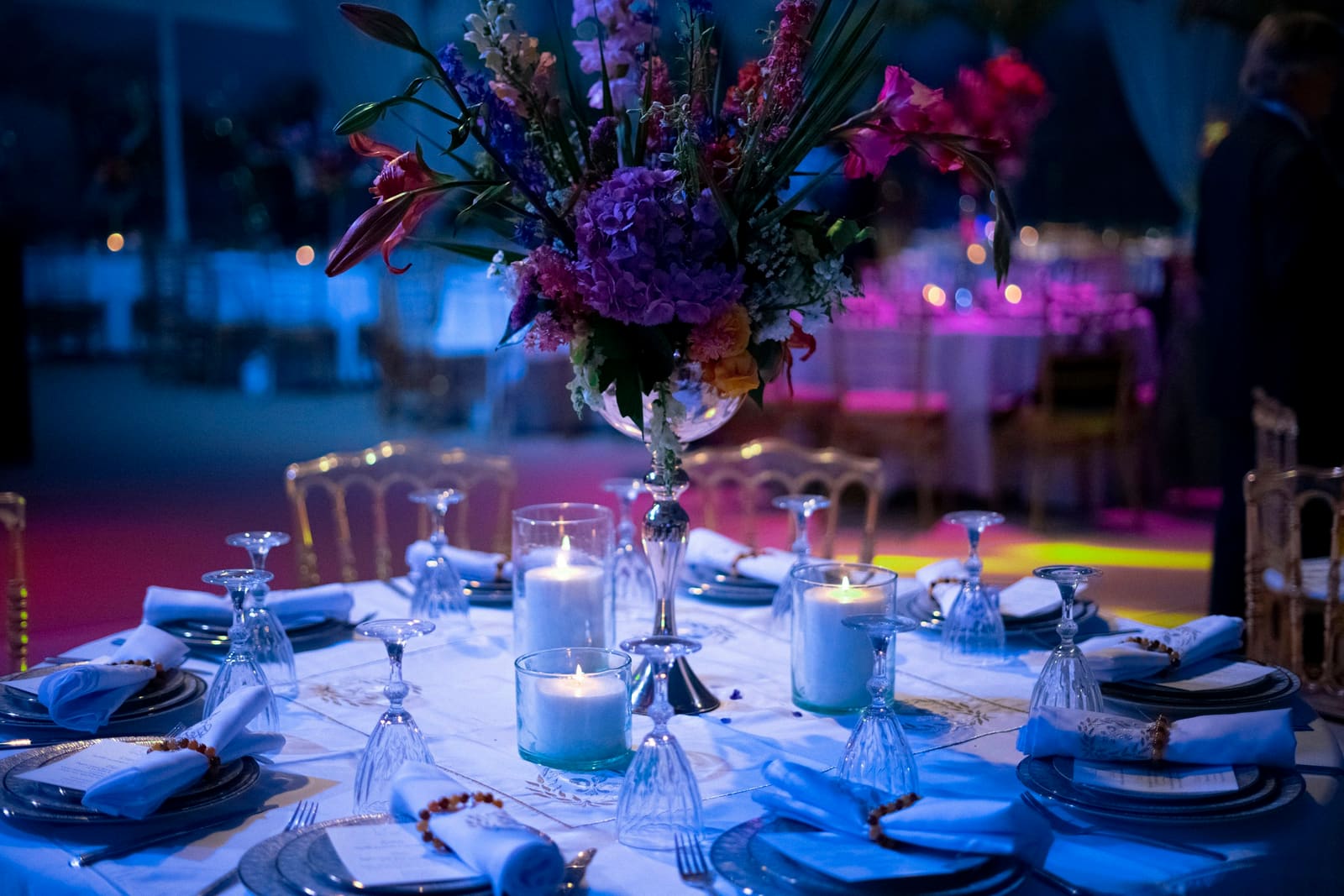 Formal candlelit dinner table with floral centerpiece and refined place settings